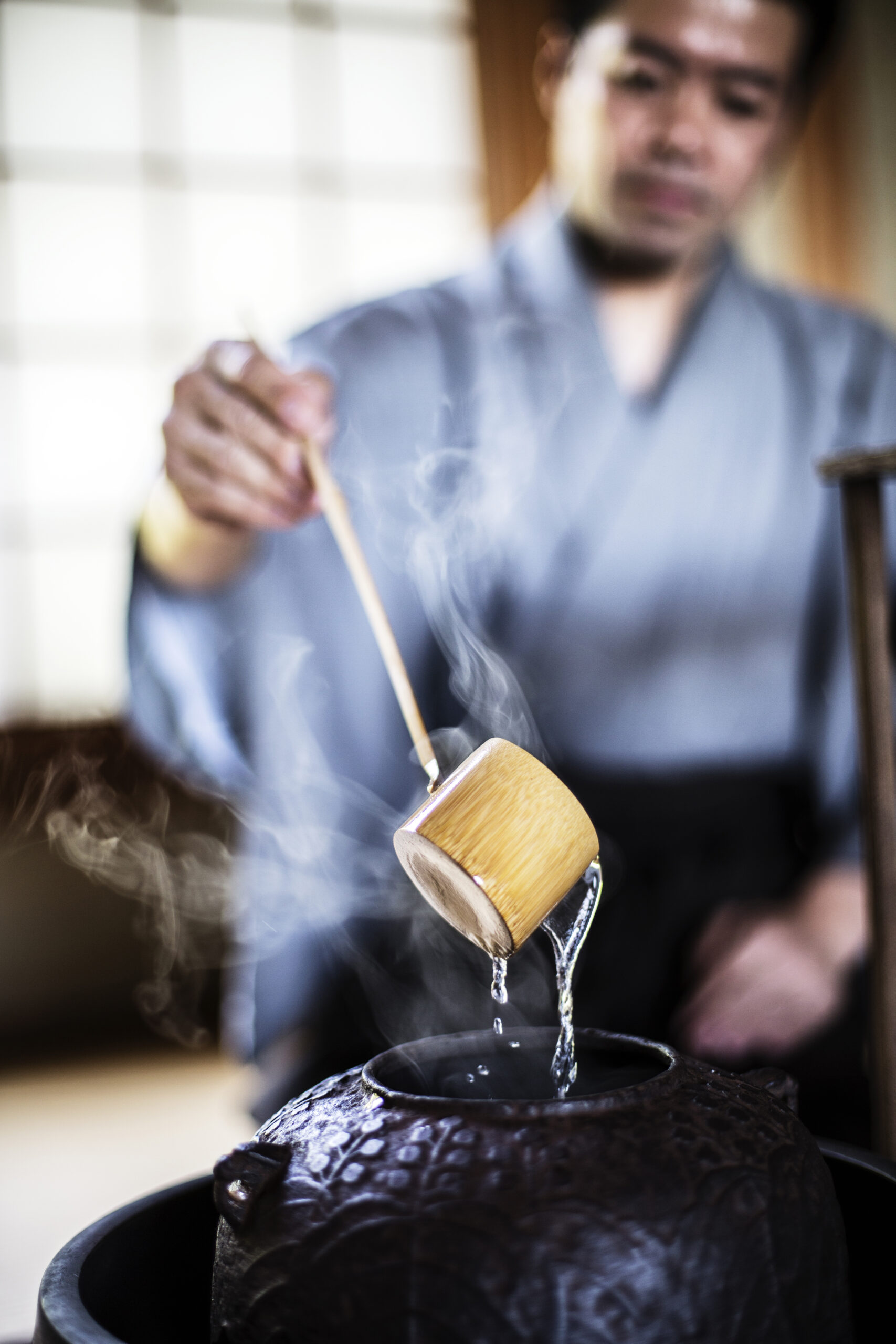 Traditional Japanese Tea Ceremony, man using a Hishaku, a bamboo ladle in water